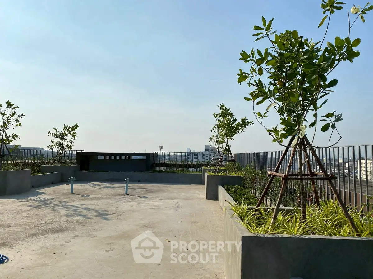 Spacious rooftop terrace with urban skyline view and greenery