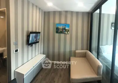Modern living room with striped wallpaper, wall-mounted TV, and cozy beige sofa.