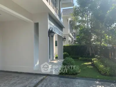 Modern townhouse exterior with lush garden and elegant lighting fixtures