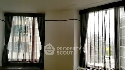 Spacious corner unit with large windows offering city views and natural light.