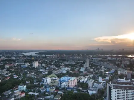 Stunning cityscape view from high-rise building at sunset, showcasing urban skyline and river.