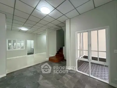 Spacious modern interior with tiled floors and glass doors, ideal for versatile living space.