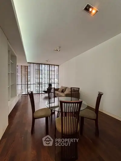 Elegant dining area with modern furniture and large windows in a spacious living room.