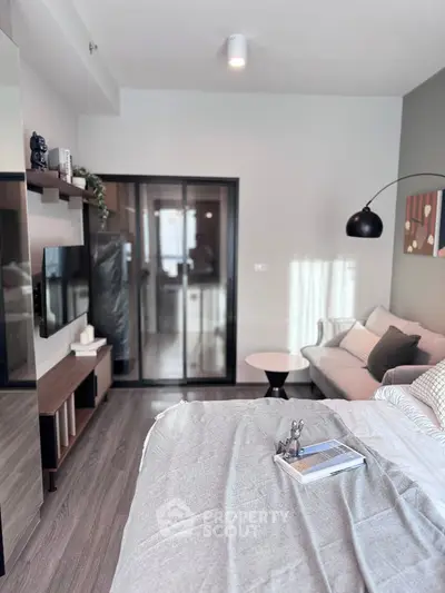 Modern living room with cozy sofa and stylish decor, featuring a sleek sliding glass door.
