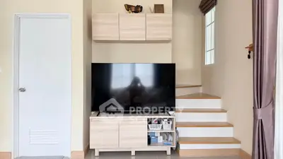 Modern living room with sleek TV unit and stylish staircase