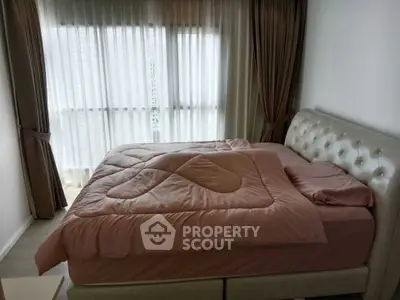 Cozy bedroom with elegant curtains and plush bedding in a modern apartment.