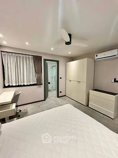 Modern bedroom with sleek furniture and ensuite bathroom in a stylish apartment.