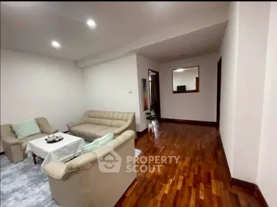 Spacious living room with elegant wooden flooring and cozy seating area.