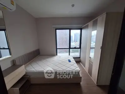 Cozy bedroom with city view, featuring a comfortable bed and ample storage space.