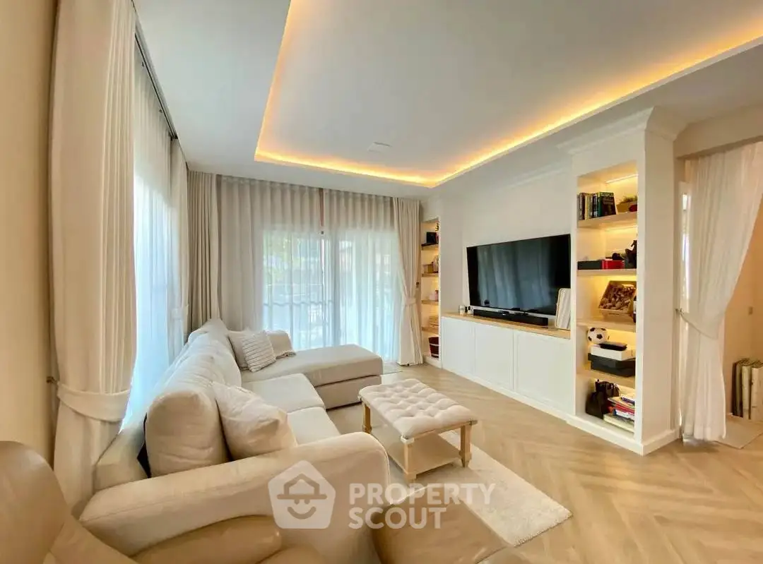 Spacious living room with elegant lighting and cozy seating area, perfect for relaxation and entertainment.