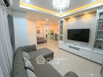 Luxurious living room with elegant chandelier and modern entertainment setup