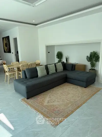 Spacious modern living room with stylish sectional sofa and elegant dining area, perfect for entertaining.