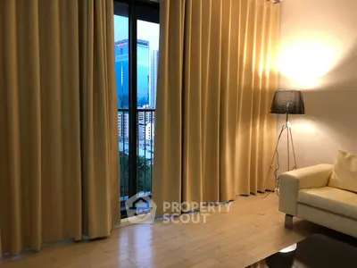 Cozy living room with floor-to-ceiling curtains and city view from balcony.