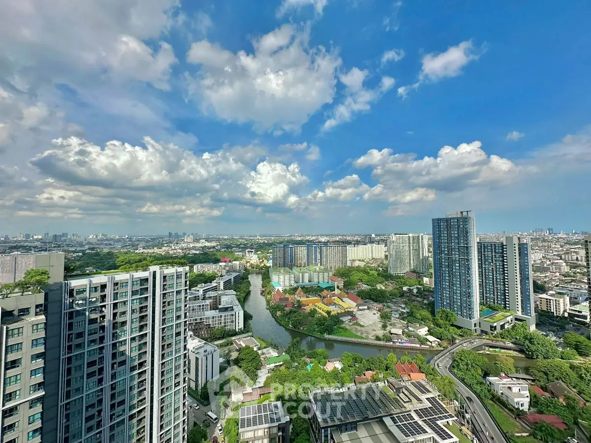 Stunning cityscape view with modern high-rise buildings and lush greenery under a vibrant blue sky.