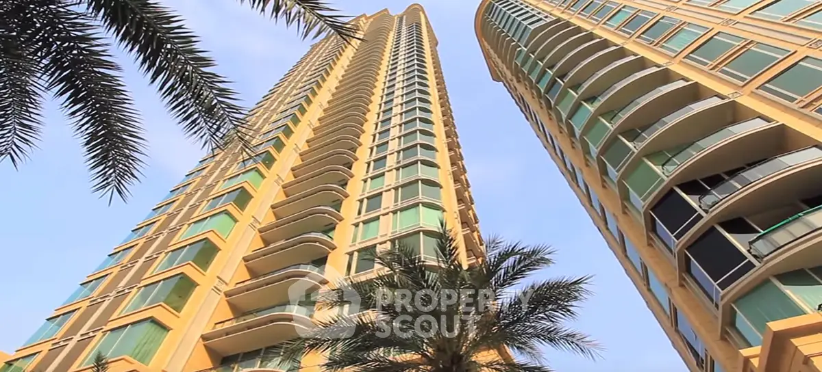 Stunning high-rise building with modern architecture and palm trees, perfect urban living.