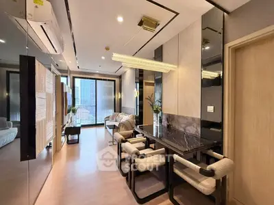 Modern living room with stylish dining area and city view, featuring sleek furniture and elegant lighting.