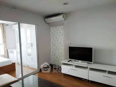 Modern living room with sleek furniture and air conditioning, adjacent to a bright bedroom.