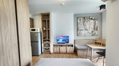 Modern studio apartment with cozy living area and compact kitchen, ideal for urban living.