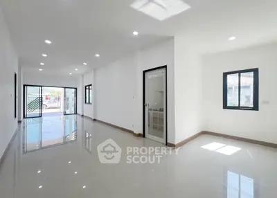 Spacious modern living room with glossy tiled floors and ample natural light.