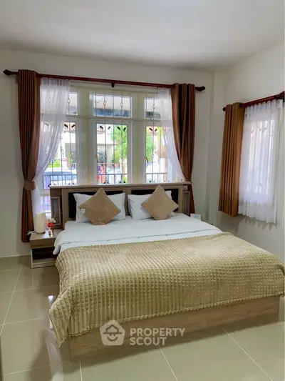 Cozy bedroom with large windows and elegant decor for a serene living experience.