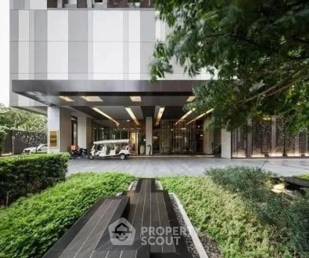 Modern building entrance with lush greenery and sleek design