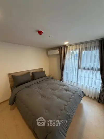 Cozy bedroom with modern decor and large window for natural light