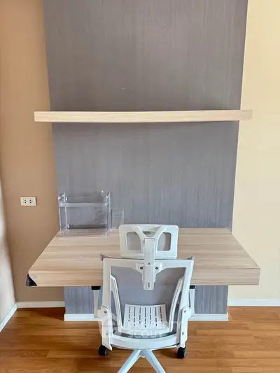 Modern study area with sleek desk, ergonomic chair, and wall shelf in a stylish home office.