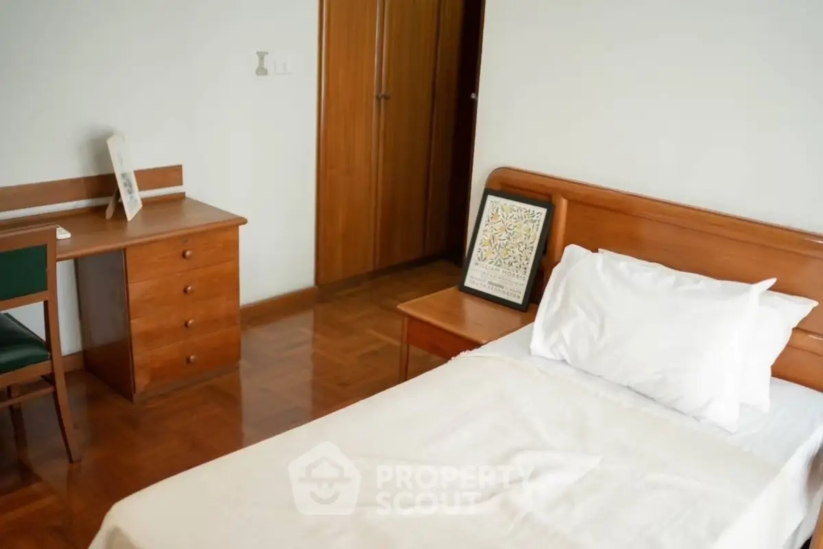 Cozy bedroom with wooden furniture and parquet flooring