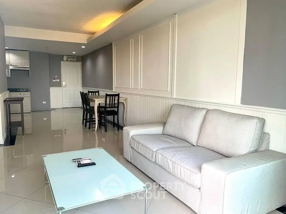 Spacious living room with modern decor and dining area in open layout apartment.