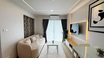 Modern living room with stylish decor, cozy sofa, and wall-mounted TV in a bright apartment.
