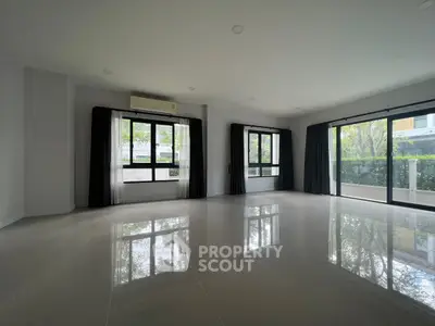 Spacious modern living room with large windows and garden view, perfect for natural light lovers.