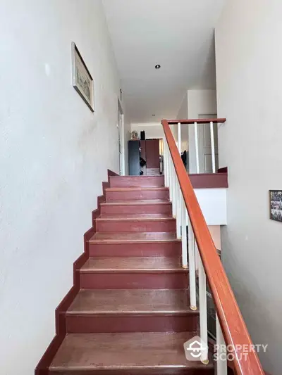 Spacious staircase with wooden railing in modern home interior