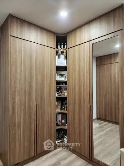 Spacious corner wardrobe with mirrored door and ample storage in modern bedroom.