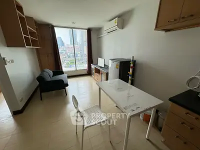 Modern studio apartment with city view, featuring compact kitchen and cozy living area.