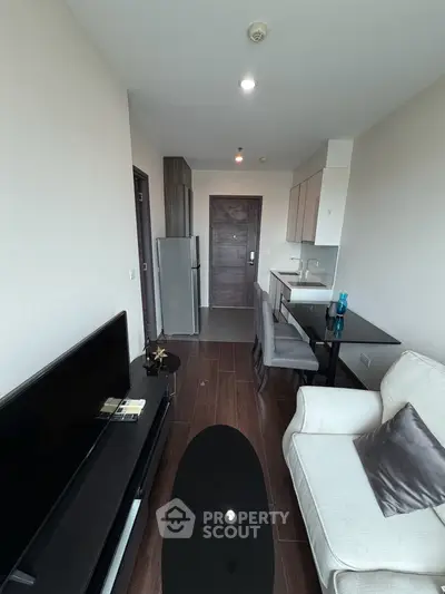 Modern living room with sleek furniture and open kitchen layout in a stylish apartment.