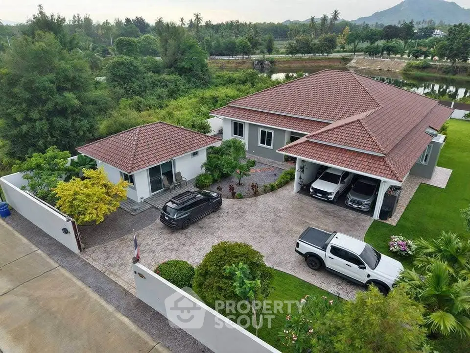 Stunning aerial view of a spacious villa with lush garden and ample parking space, perfect for luxurious living.