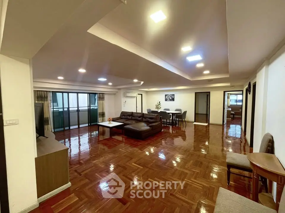 Spacious living room with elegant wooden flooring and modern furniture in a luxurious apartment.