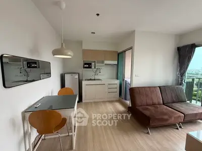 Modern open-layout living room with kitchenette and balcony view