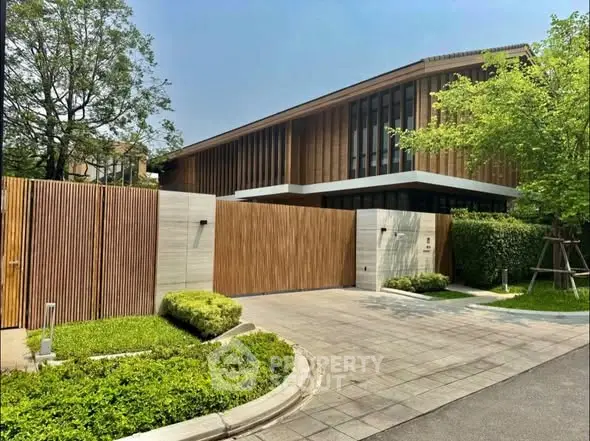 Modern luxury house with wooden facade and lush greenery