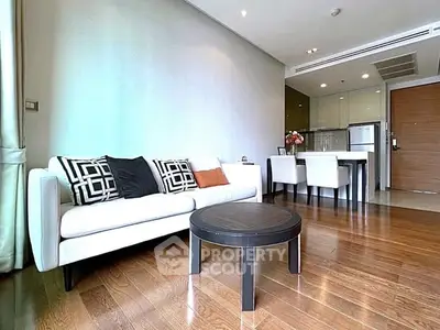 Modern living room with stylish sofa and dining area in open layout apartment.
