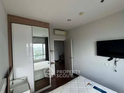 Modern bedroom with city view, featuring sleek furniture and wall-mounted TV.