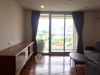 Spacious living room with large window and scenic balcony view