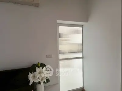 Minimalist interior with frosted glass window and elegant floral decor