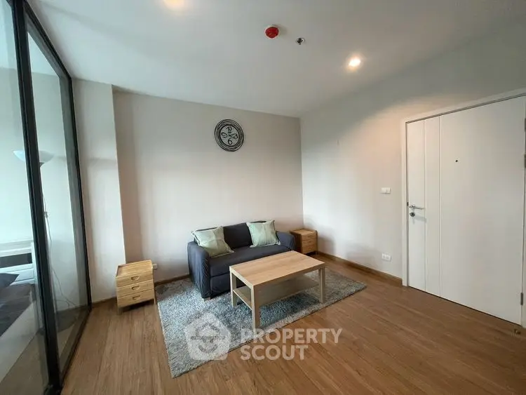 Modern living room with wooden flooring and minimalist decor in a cozy apartment.