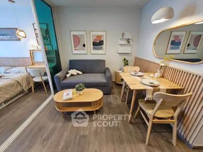 Modern living room with cozy dining area and stylish decor in open-plan apartment.