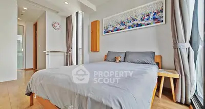 Modern bedroom with large windows and stylish decor in a high-rise apartment.