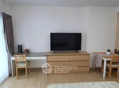 Modern living room with sleek TV setup and stylish furniture in a cozy apartment.