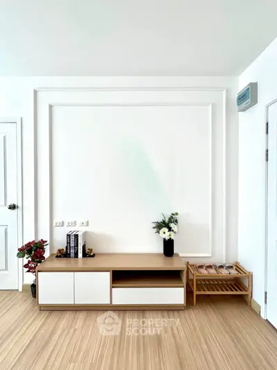 Modern minimalist living room with stylish wooden furniture and elegant decor accents.