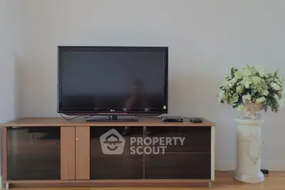 Modern living room with sleek TV stand and elegant floral arrangement