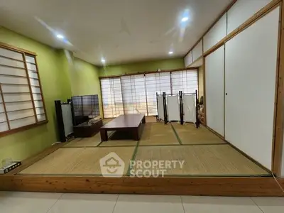 Spacious Japanese-style living room with tatami flooring and shoji screens, perfect for serene living.